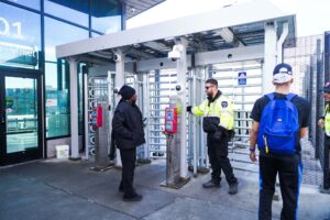 Photo of customers and guard by new Secure Platform security gates