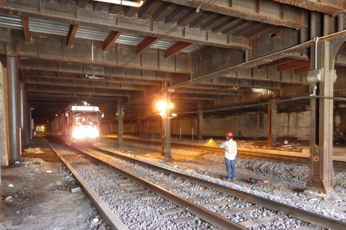 A train passes a construction worker in the Union Station Tunnel.